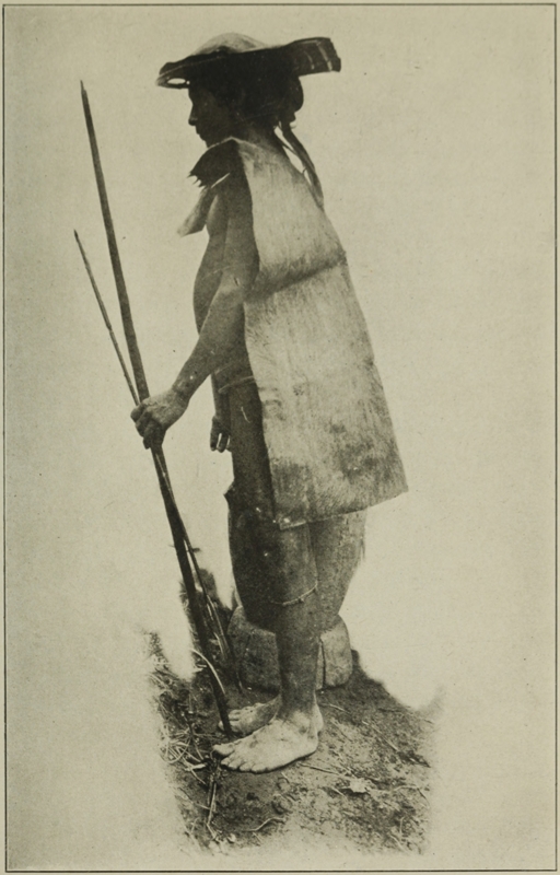 ILONGOT IN RAIN-COAT AND HAT OF DEERSKIN.